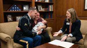 A joyful family with their newborn meets a Babytree Surrogacy advisor, sharing smiles and discussing important papers together. babytree