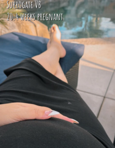 A pregnant surrogate for Babytree Surrogacy relaxes outside by a pool at 20.4 weeks, showing calmness and care. babytree